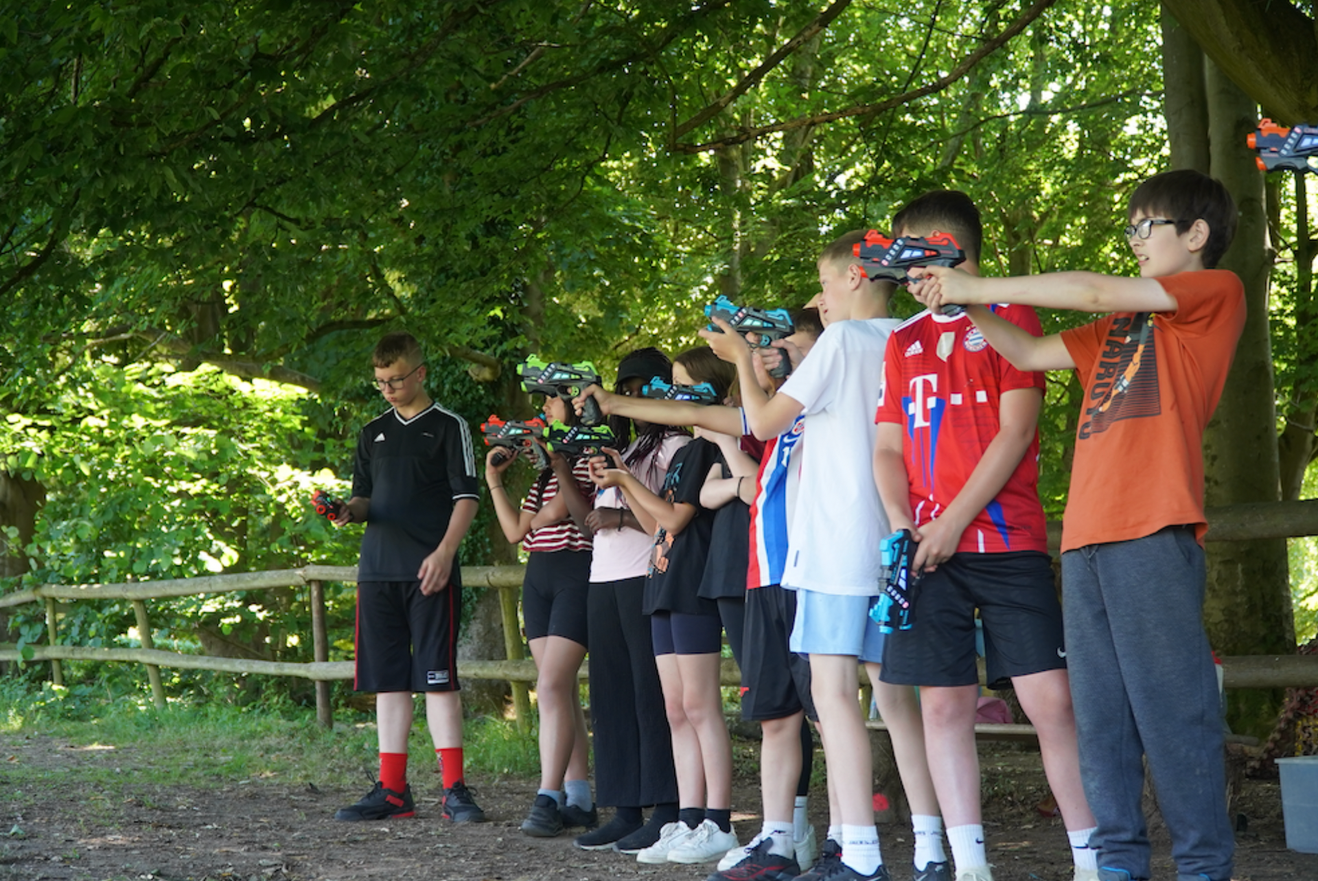 A group of children playing laser tag in the woods on a School Trip outdoor activity centres