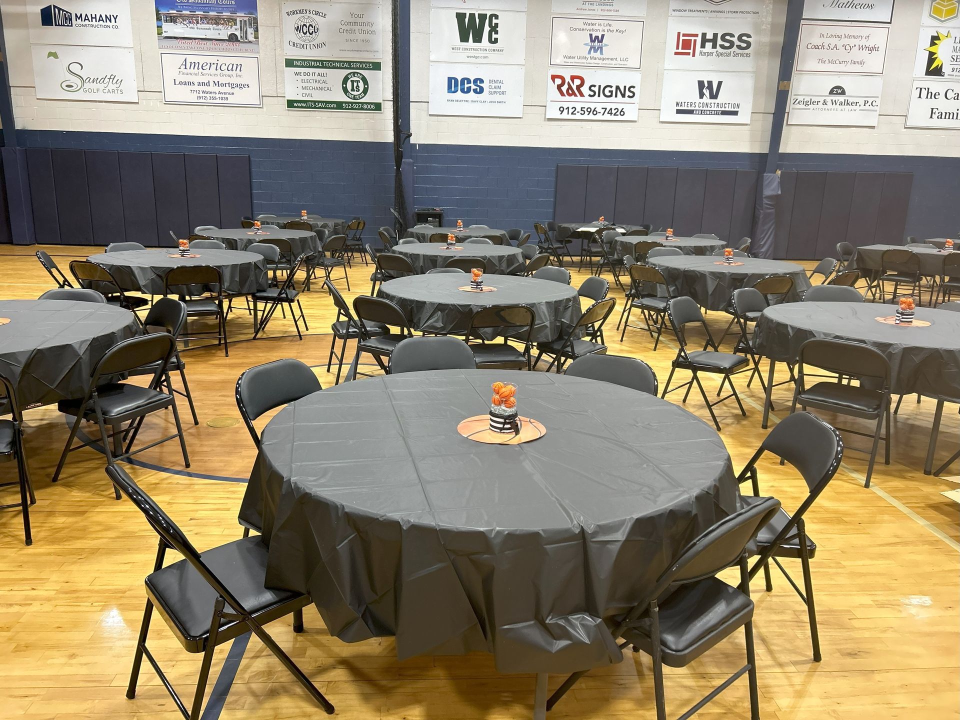 A large room with tables and chairs set up for a party.