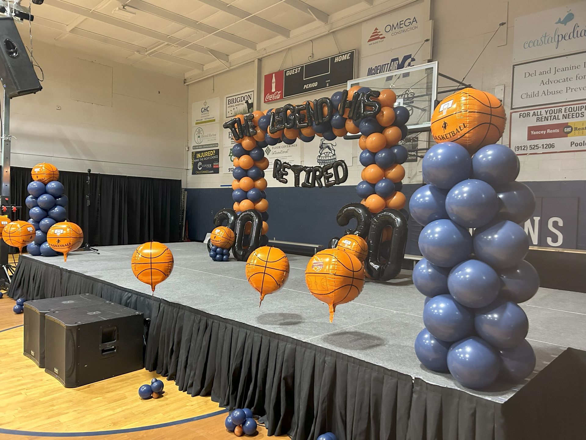 A stage decorated with balloons and a sign that says retired