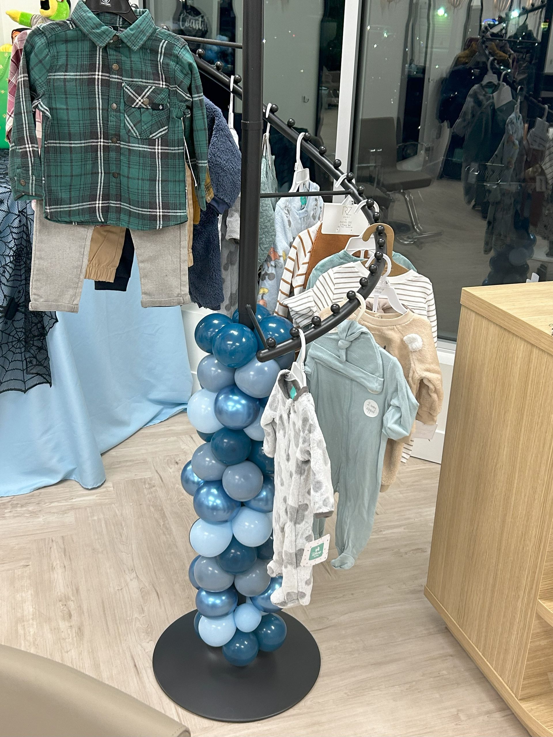 A display of clothes in a store with balloons on it.