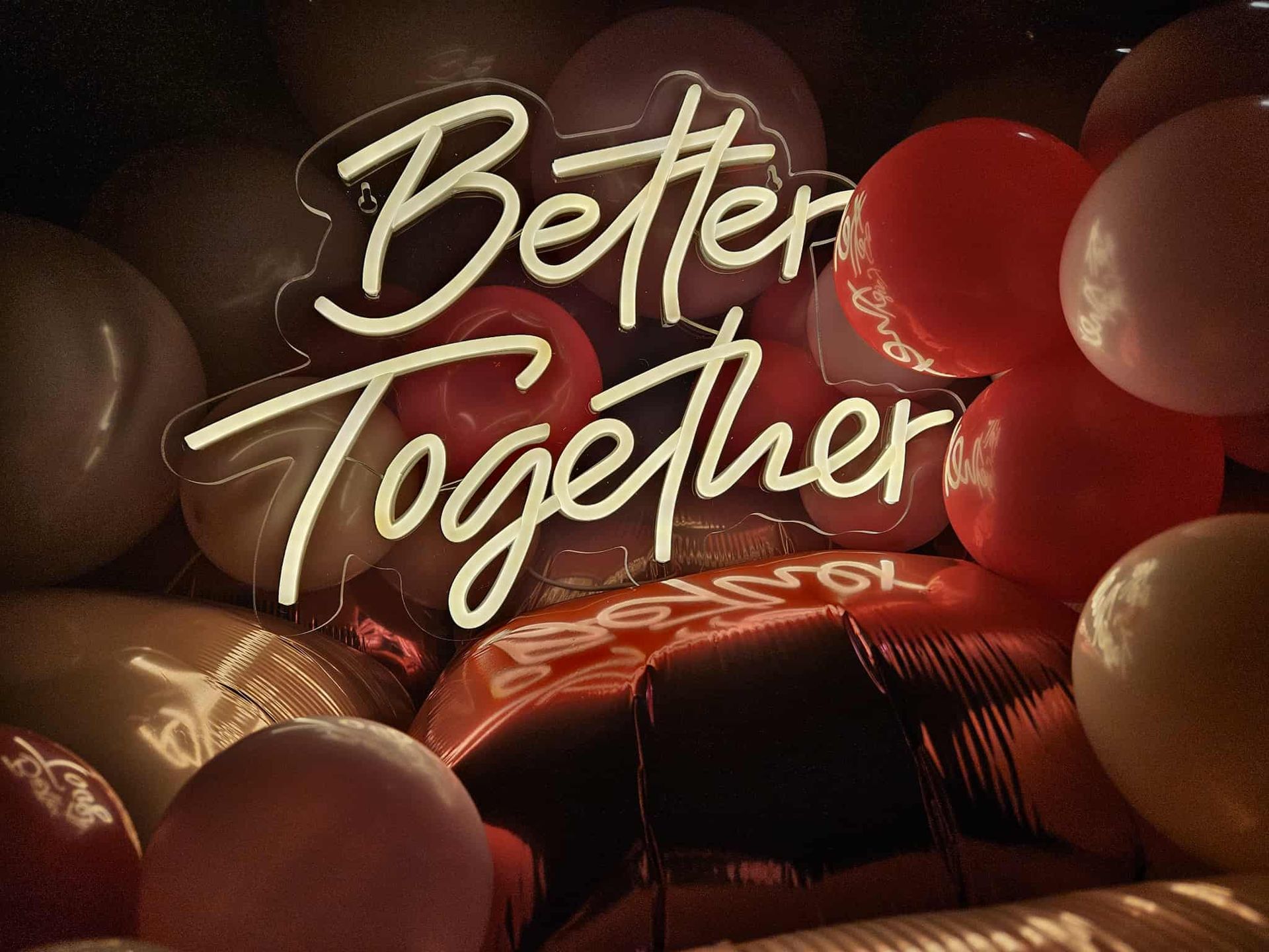 A long wooden table and chairs are set for a wedding reception.