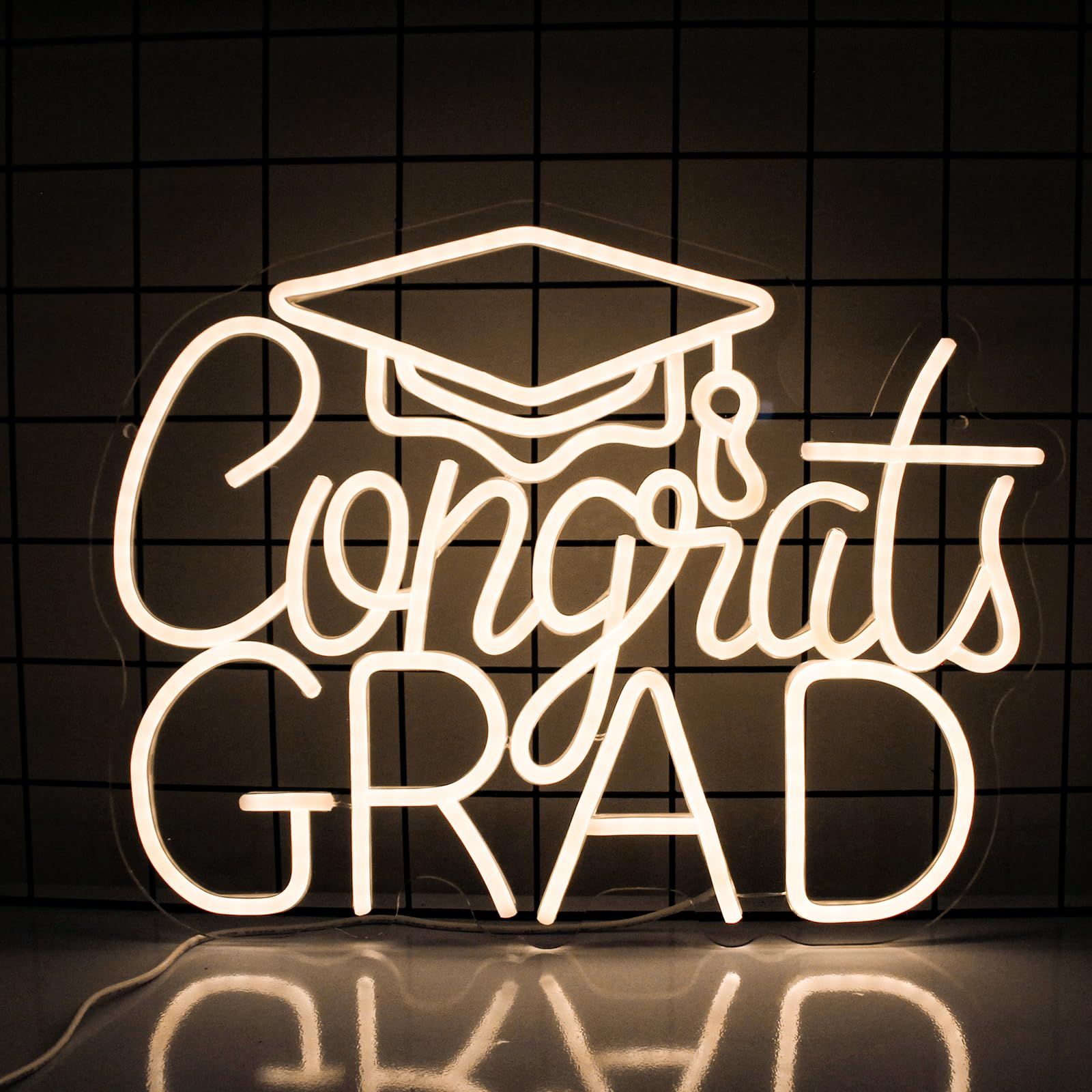 A neon sign that says congrats grad with a graduation cap