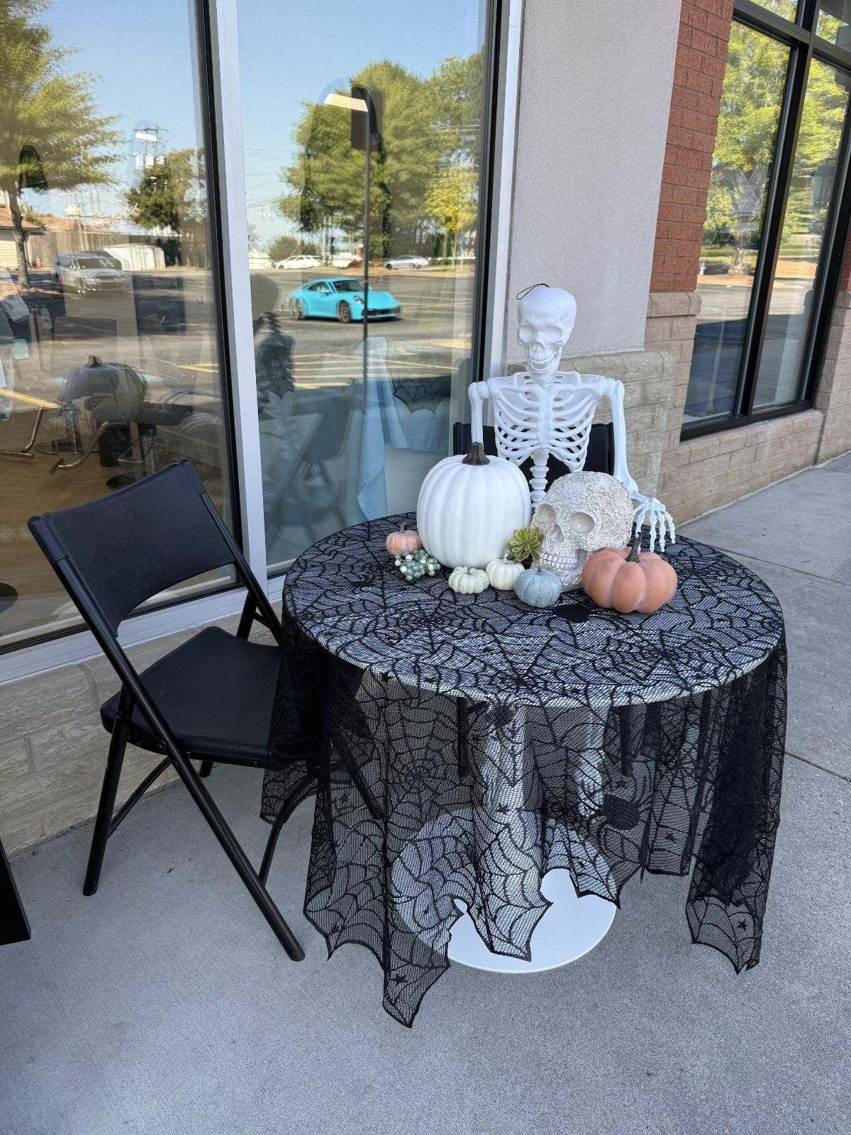 A table with a skeleton and pumpkins on it