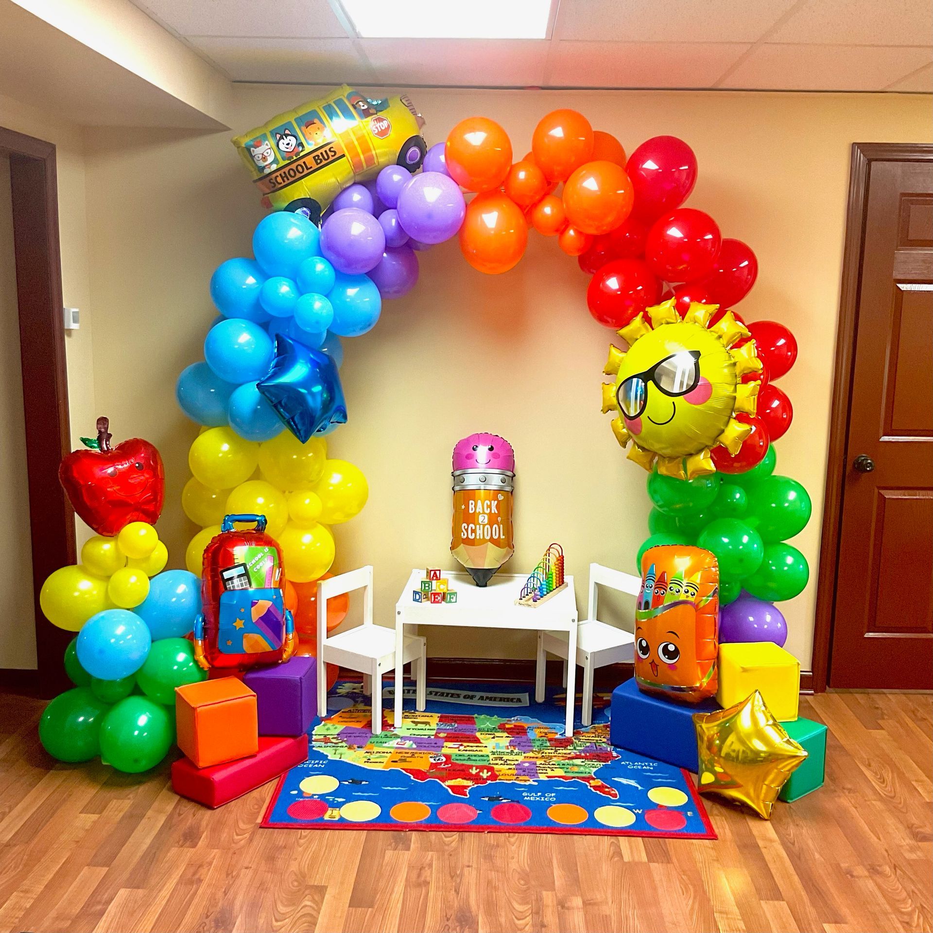 A room decorated with balloons and toys for a birthday party.