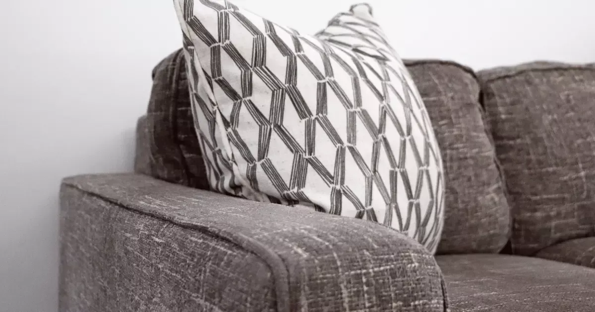 Close-up of a brown sofa with a patterned pillow, showcasing upholstery before sofa steam cleaning