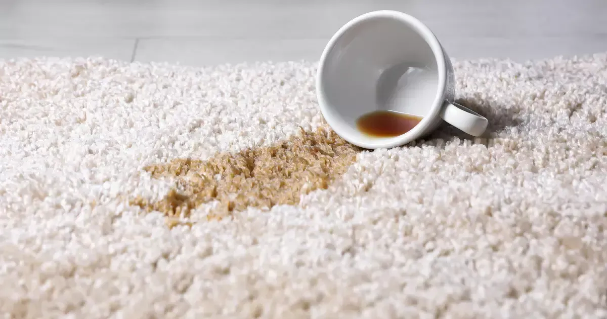 A spiled cup of coffee on a cream carpet