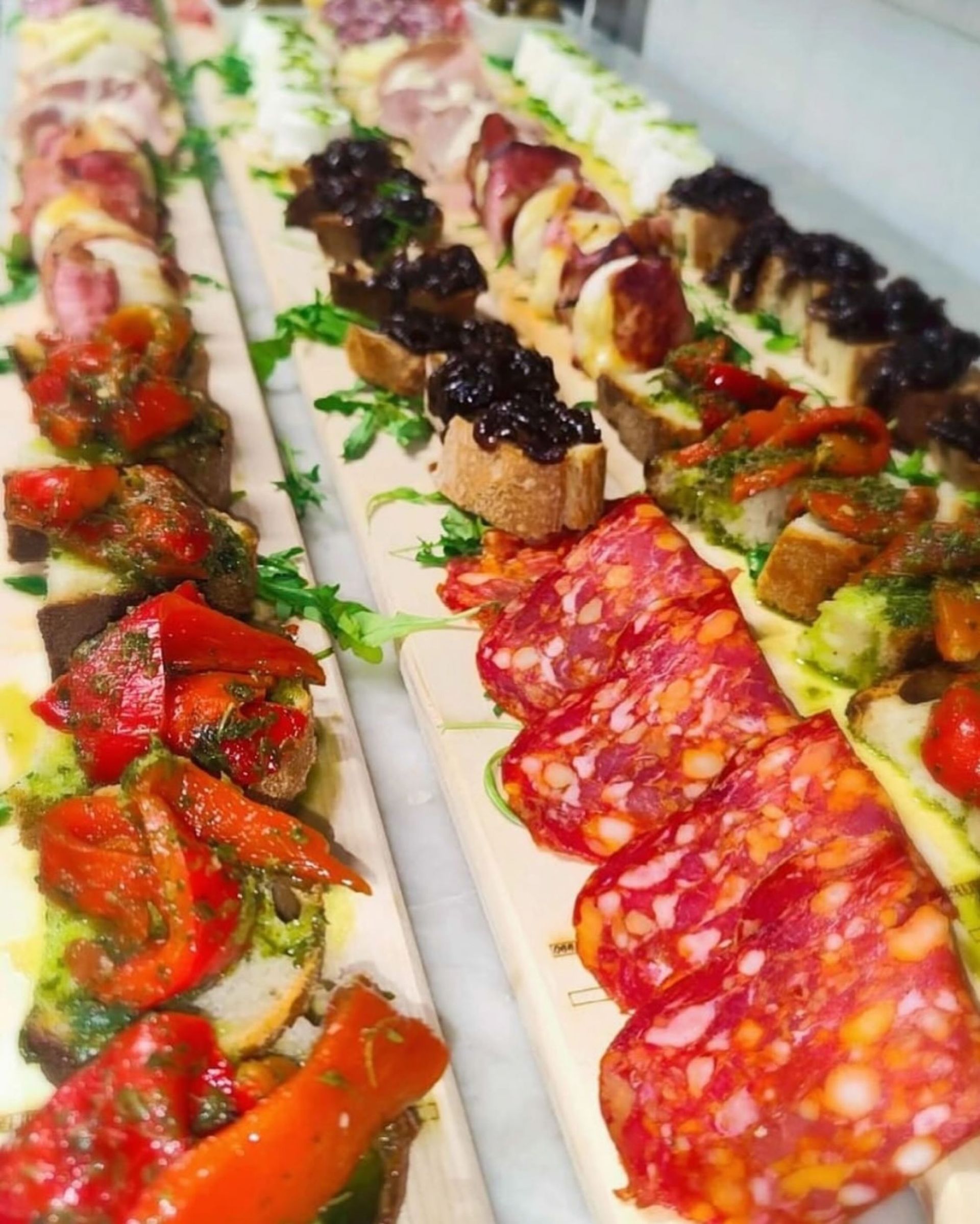 taglieri con diverse leccornie: salumi, bruschette e verdure
