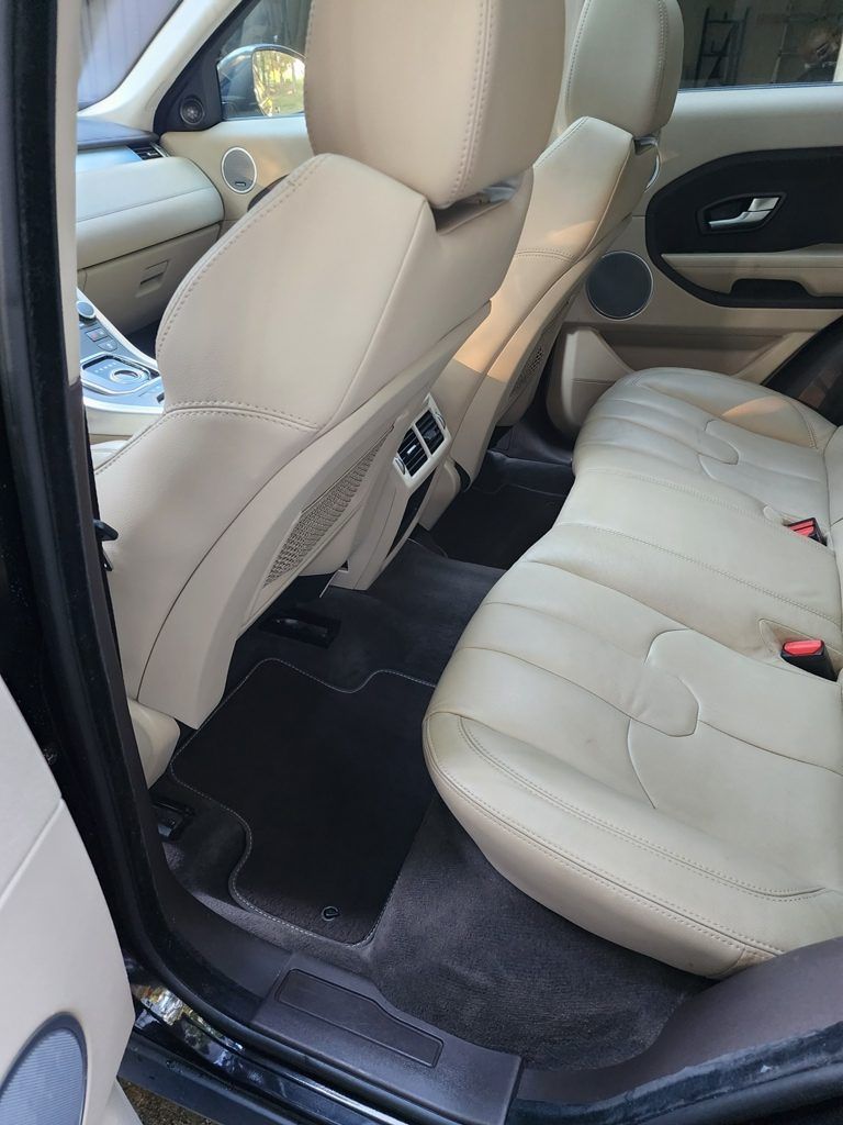 The interior of a range rover evoque is shown with the door open.