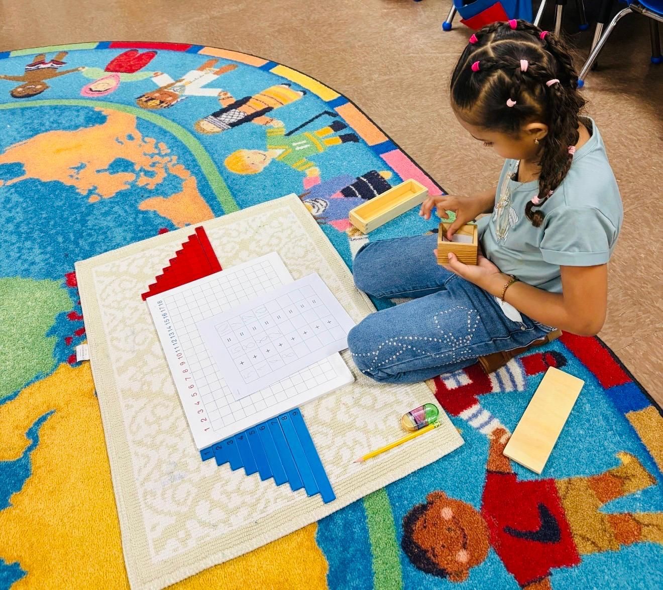 A group of children are sitting around a table in a classroom.