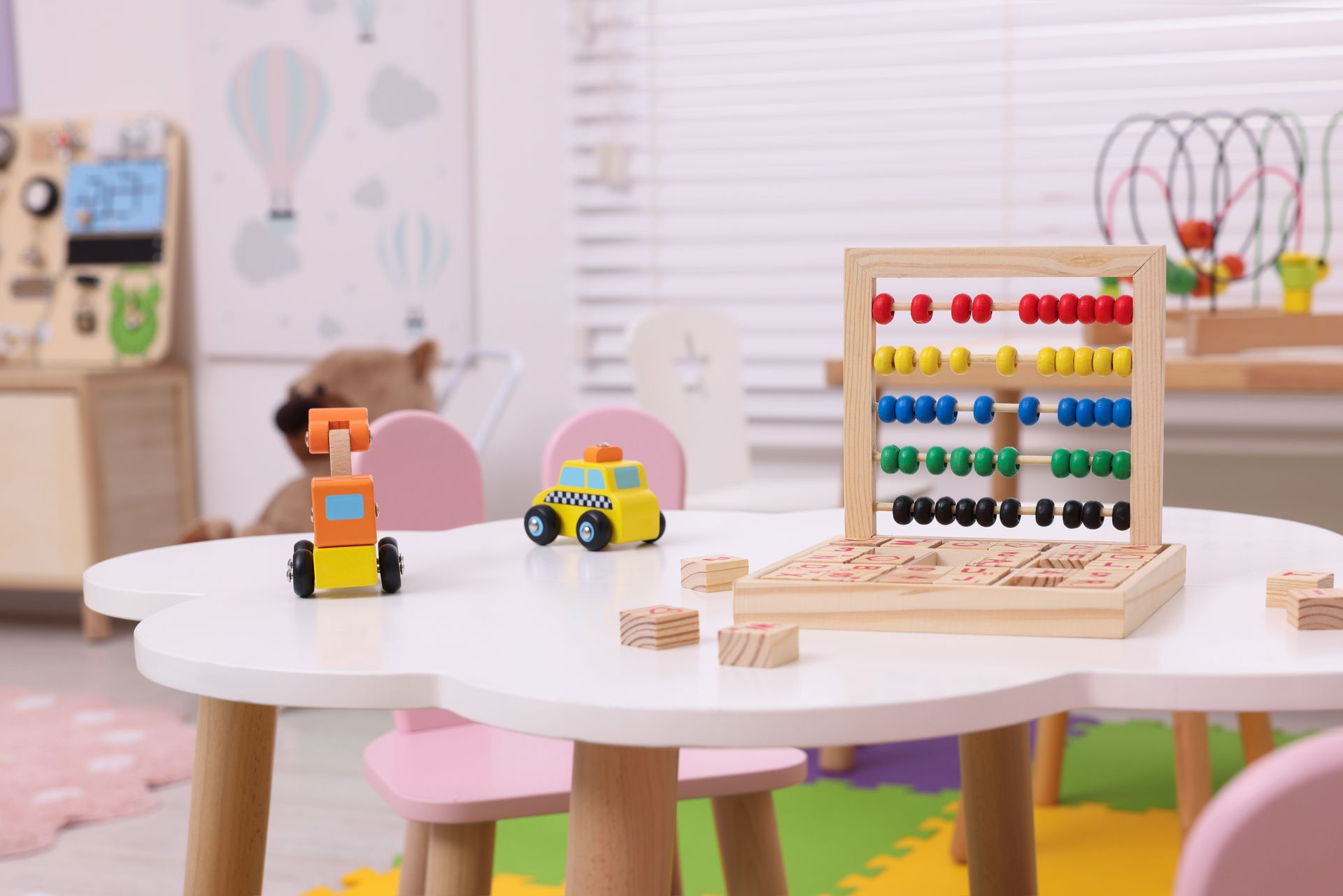 A table with toys and an abacus on it in a play room.
