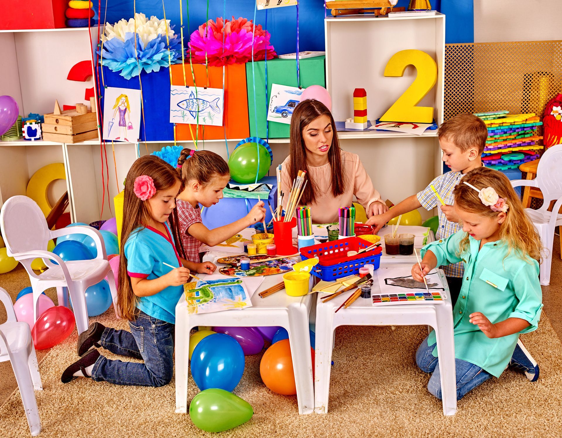 A group of children are sitting around a table in a classroom.