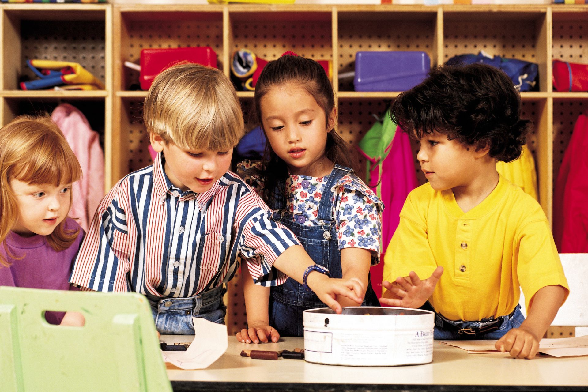 A group of children are playing with a projector in a classroom
