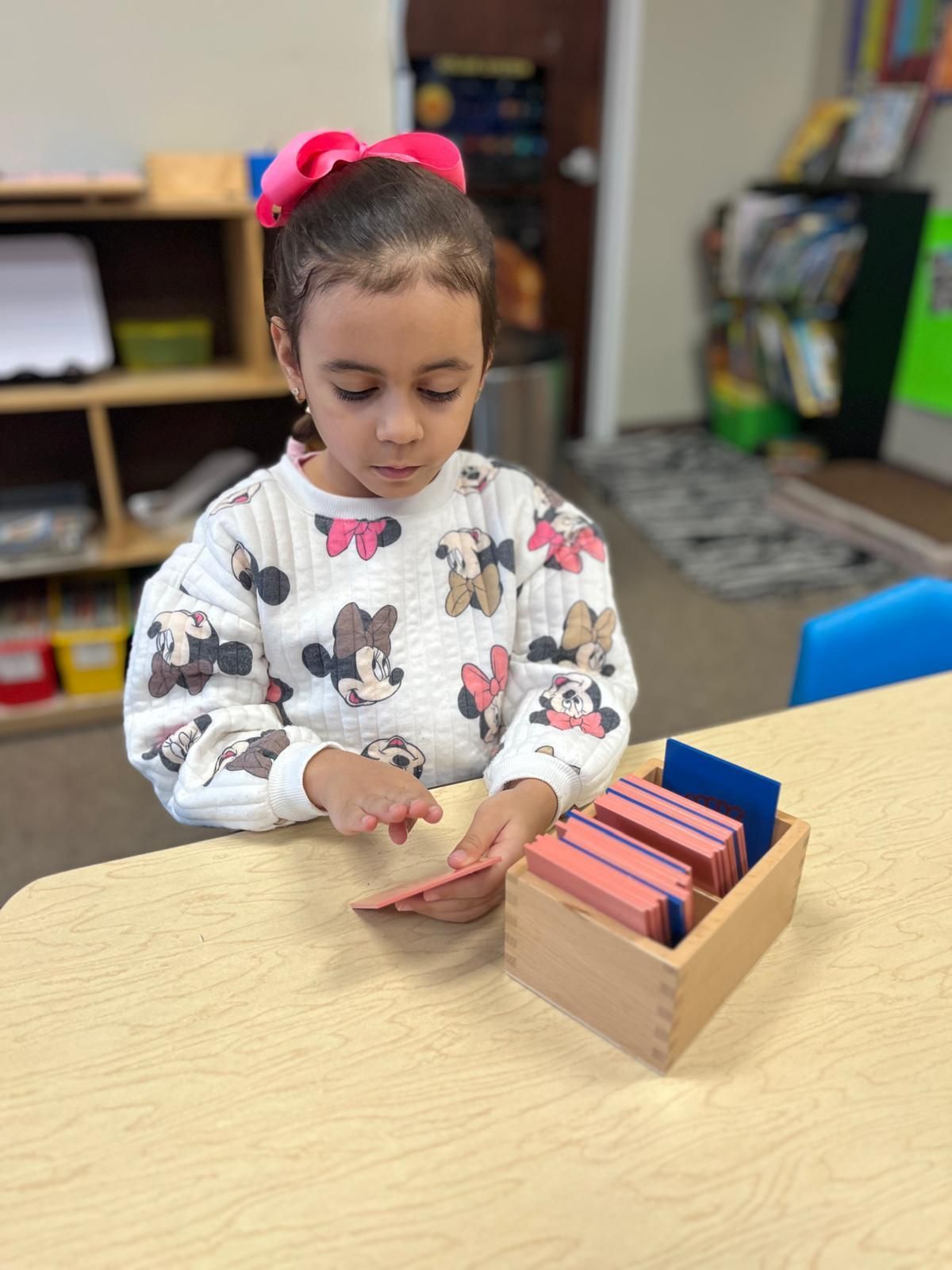 A little girl with her hands covered in paint.