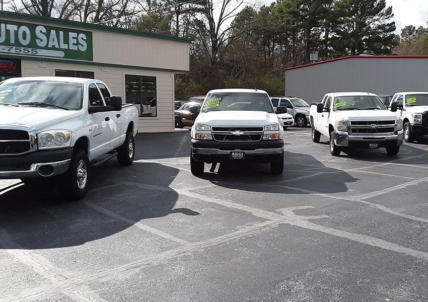 Black Ford Crown Victoria sedan parked outside on a sunny day.