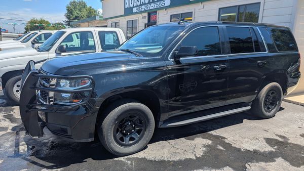 Black SUV with a push bar parked outside a building with the words