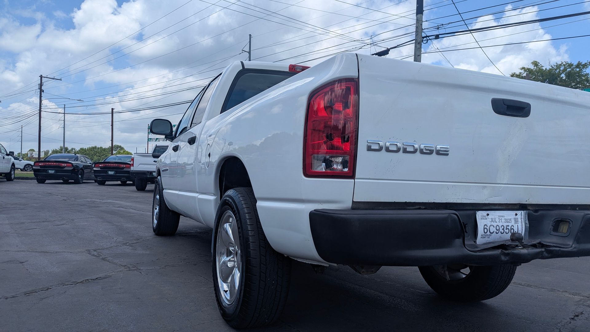 White Dodge Ram pickup truck in a parking lot on a cloudy day.