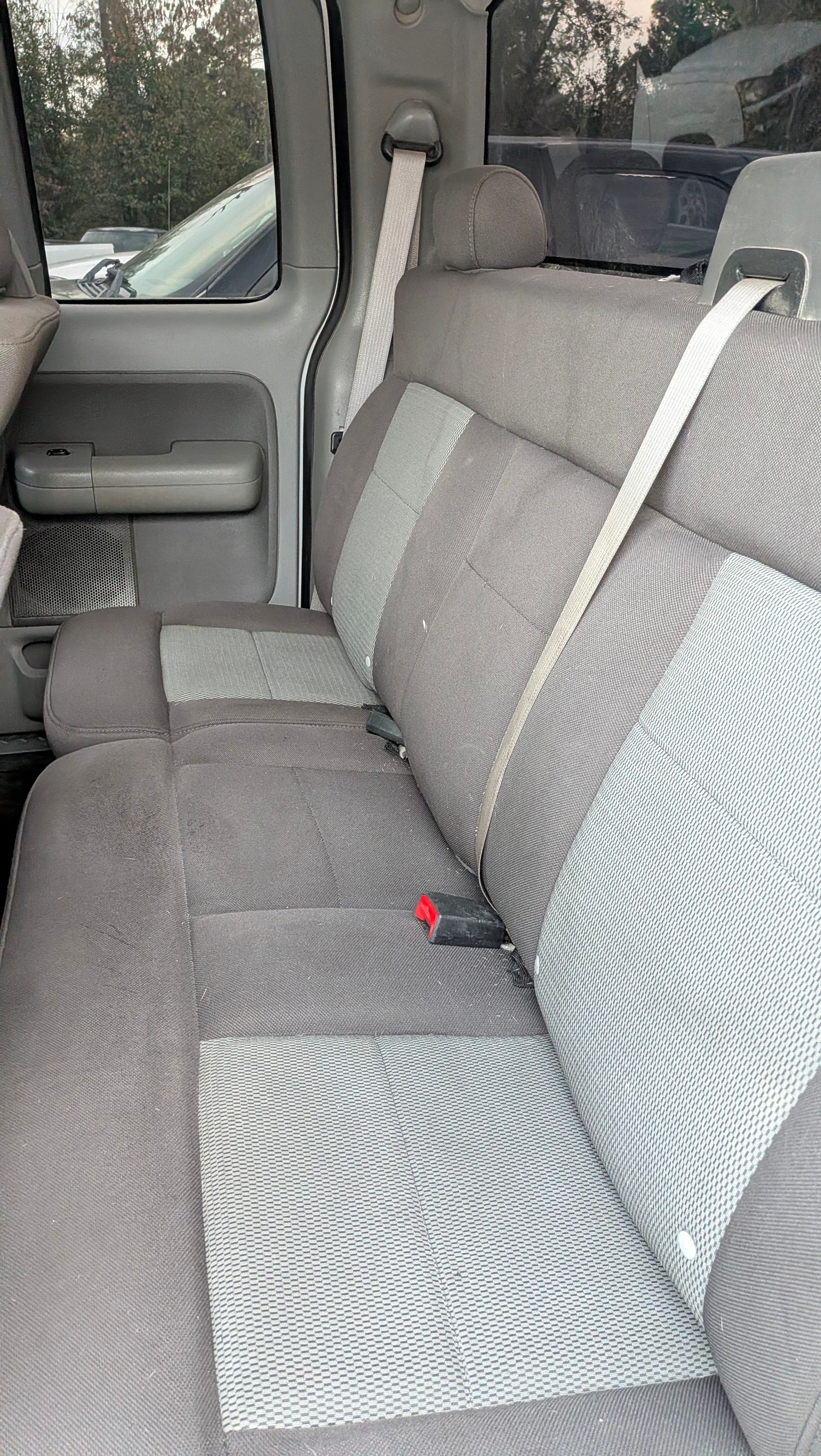 Gray and light blue truck back seat with seat belts.