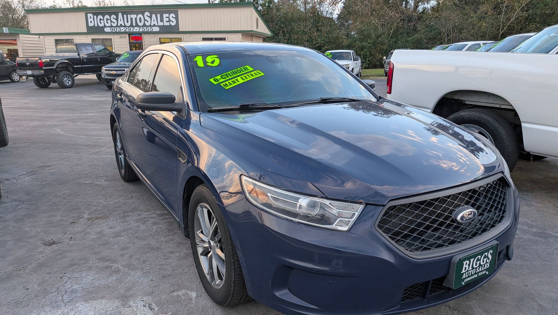 Blue Ford Taurus sedan at a car dealership with a 