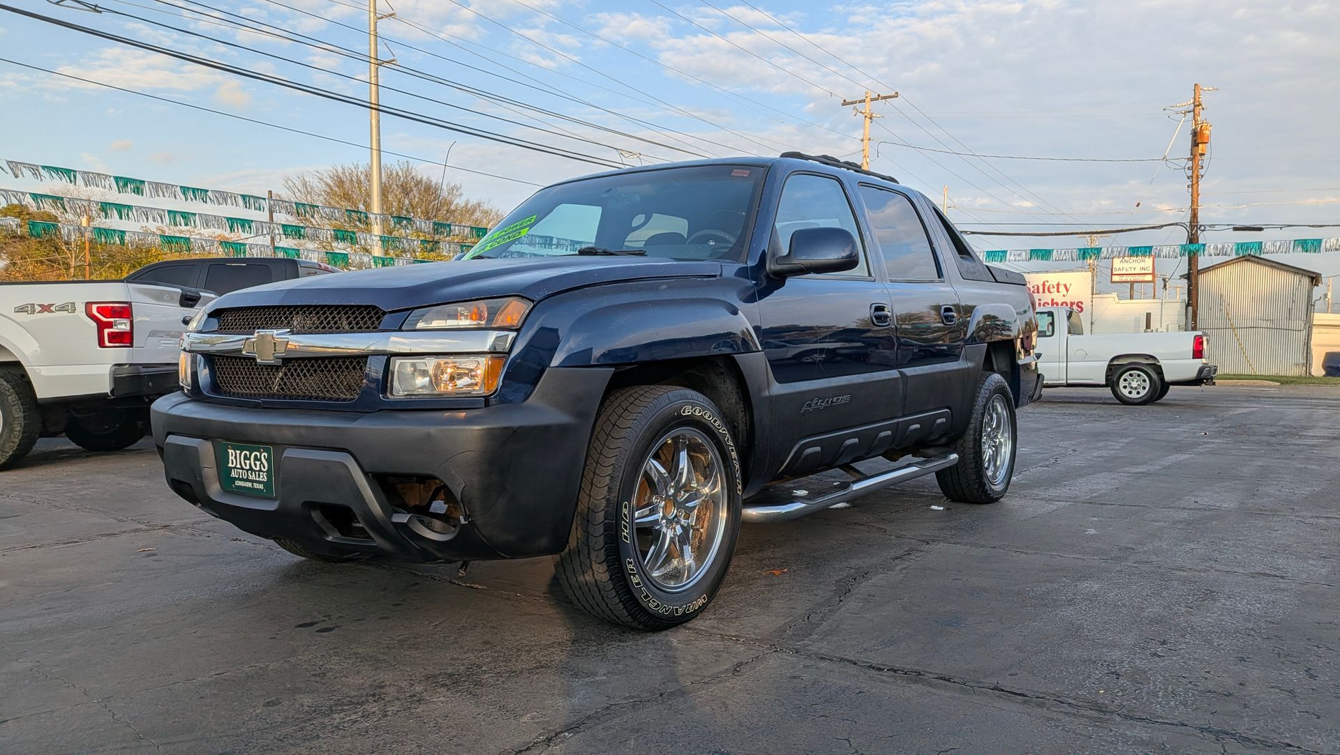 Blue Chevrolet Avalanche truck parked on asphalt lot.