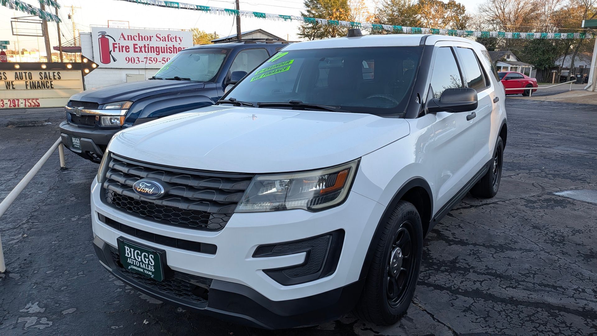 White Ford Explorer SUV parked outdoors; other vehicles and buildings in background.
