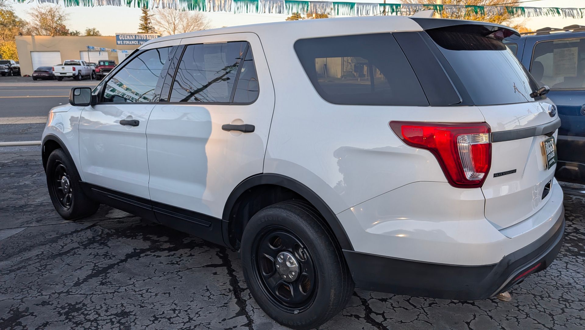 White SUV with black wheels parked outside.