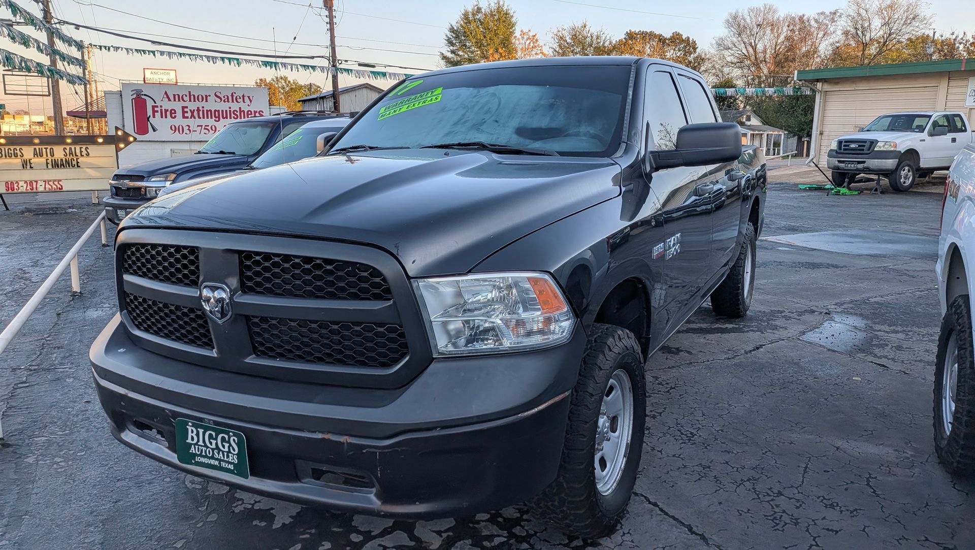 Black Dodge Ram pickup truck parked outside a dealership.