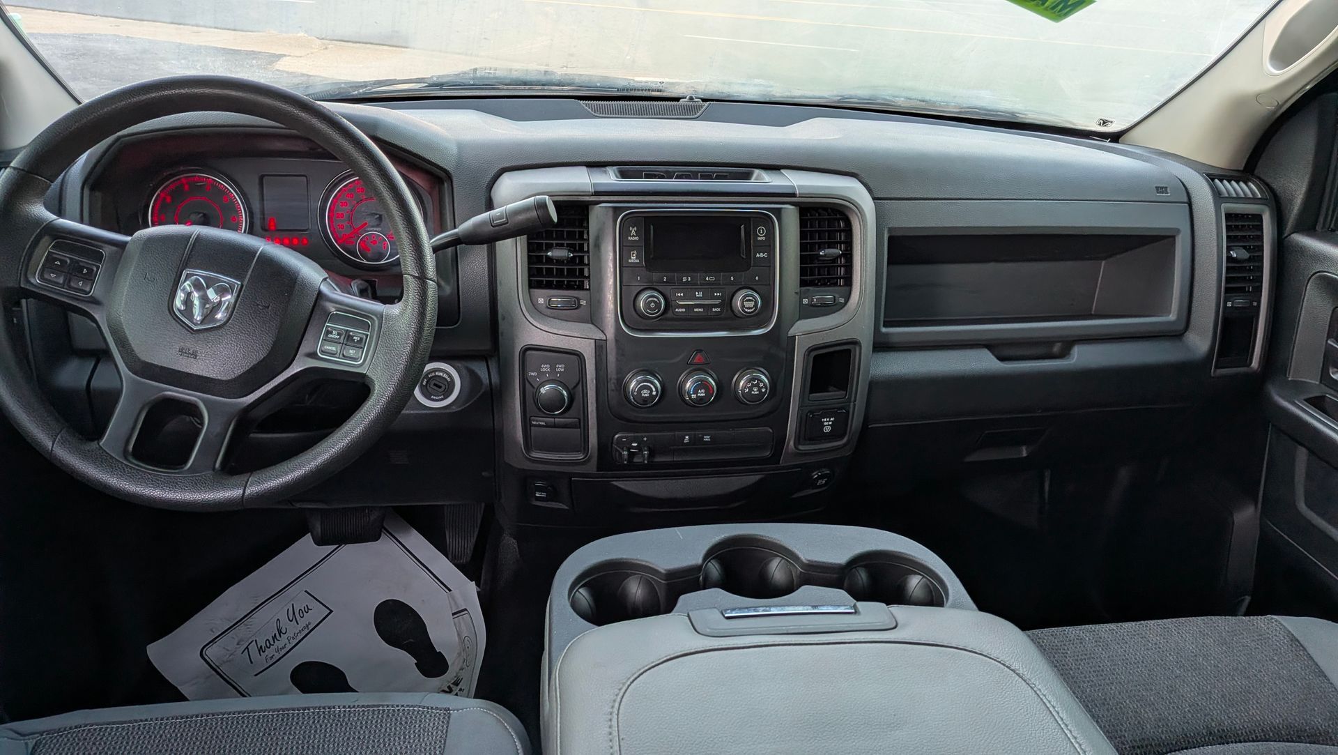 Truck interior showing dashboard, steering wheel, and center console. Gray and black tones.