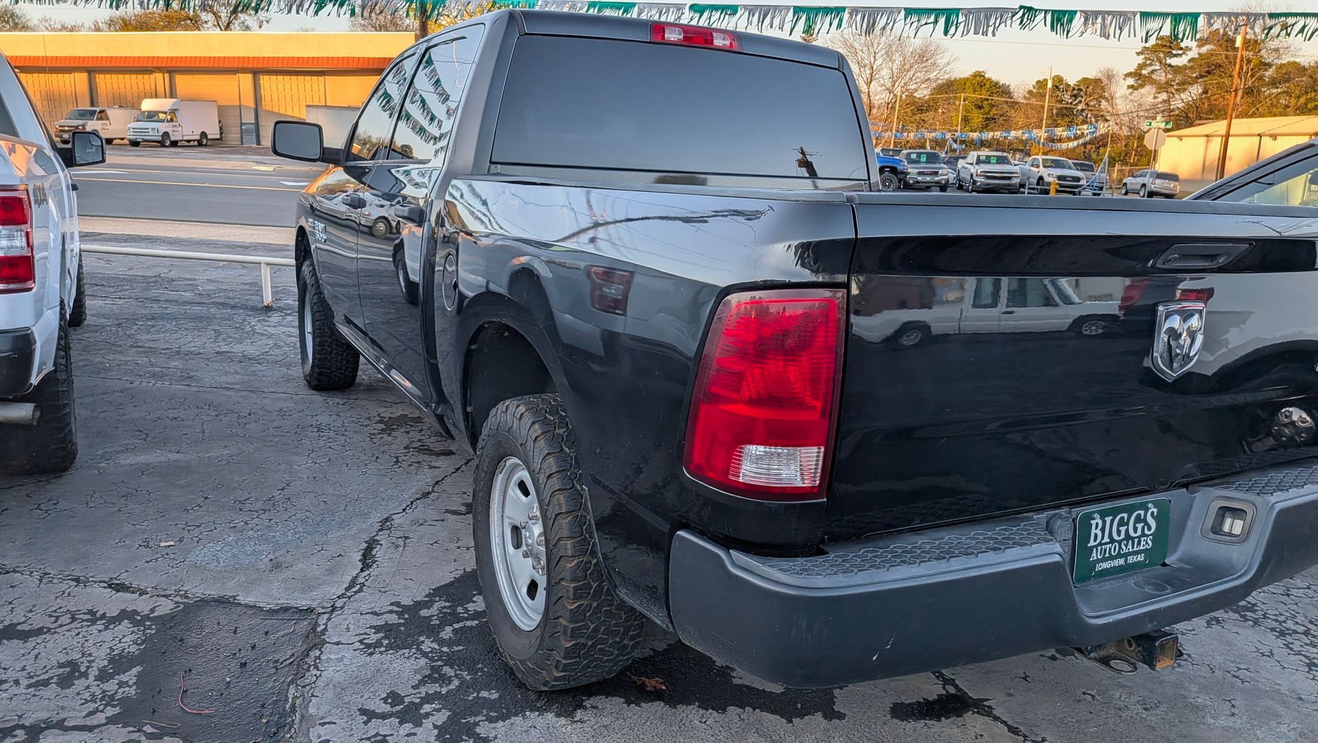 Black Dodge Ram pickup truck parked on asphalt lot.