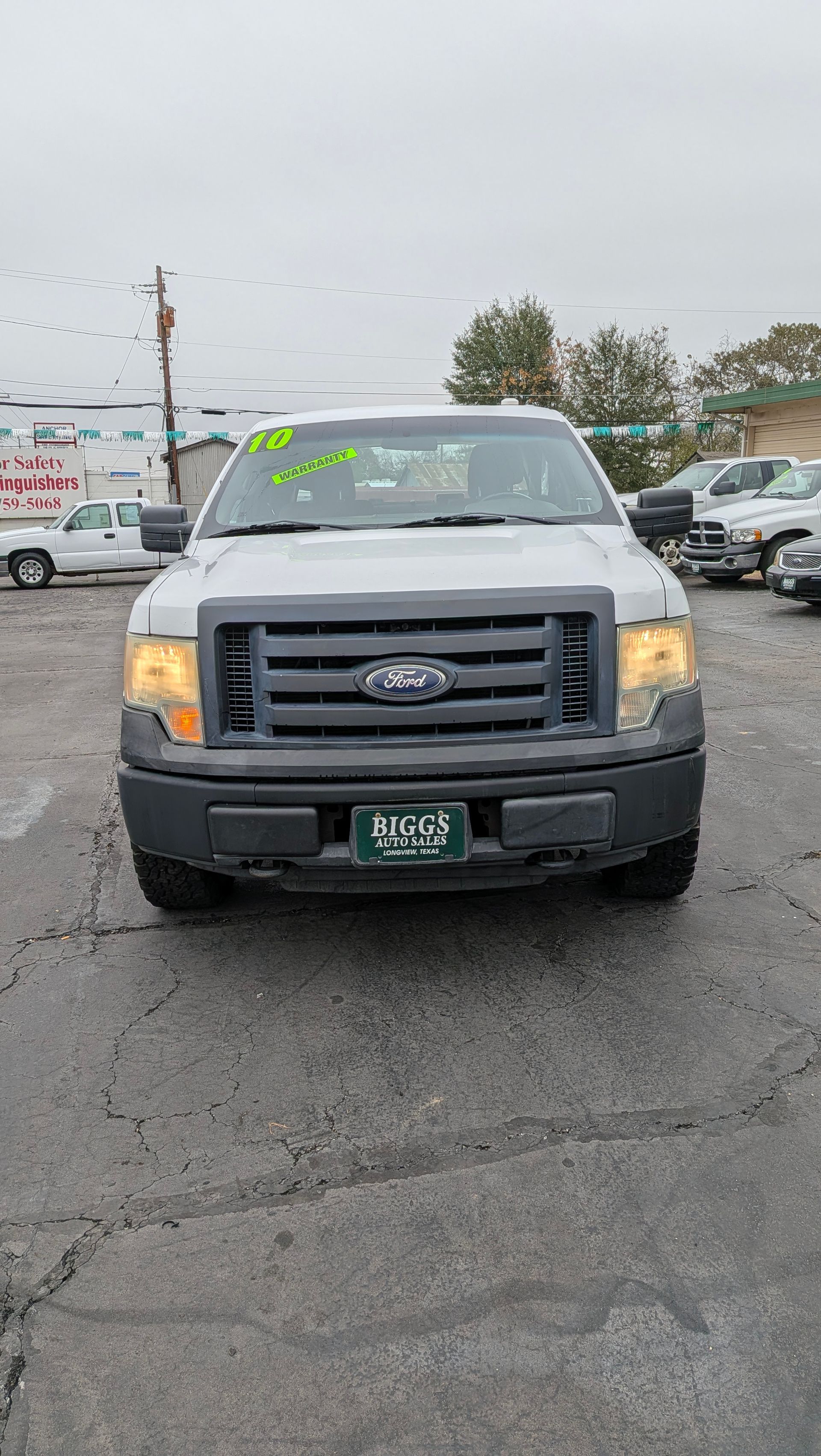A silver Ford F-150 truck parked in a lot; overcast sky overhead.