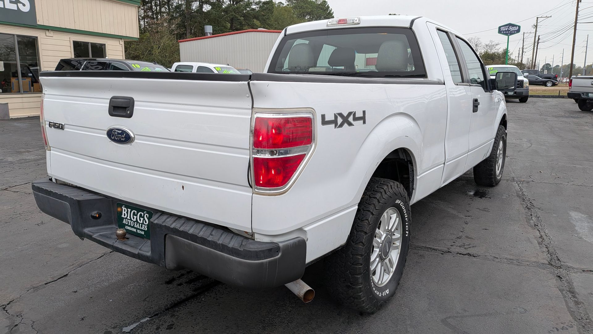 White Ford F-150 pickup truck parked on asphalt, 4x4 emblem visible.