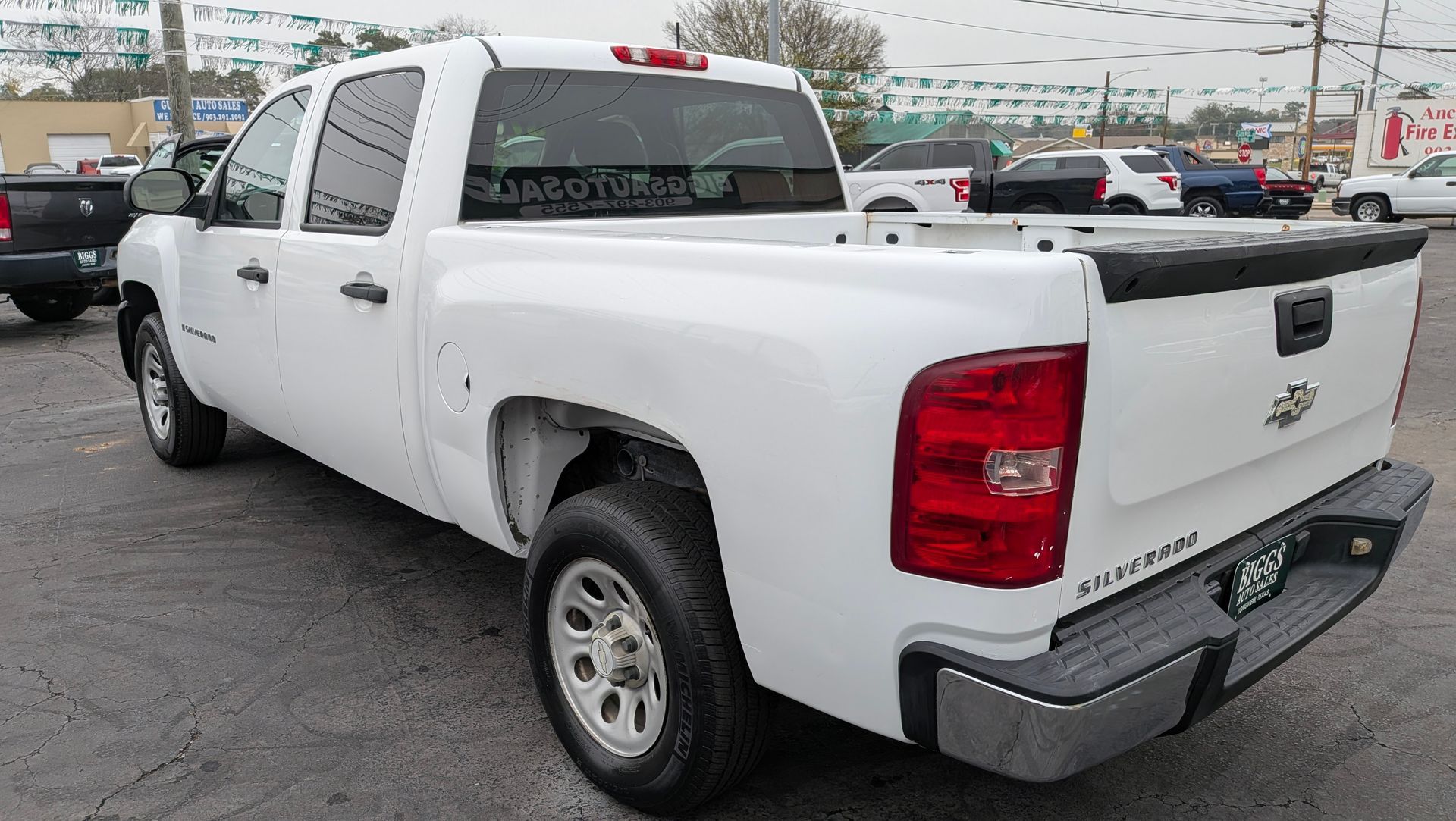 White Chevrolet Silverado pickup truck on a paved lot, viewed from the rear corner.