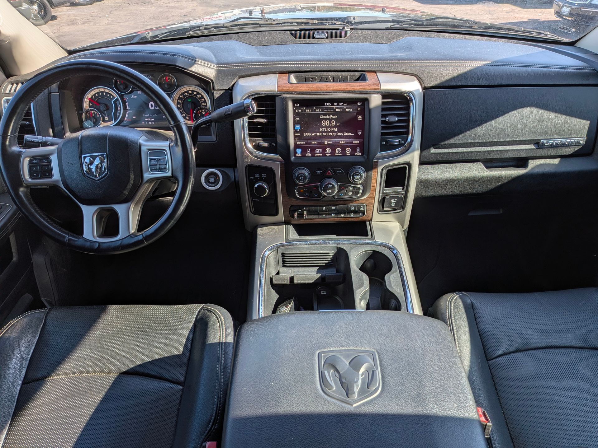 Interior of a Ram truck, dashboard with steering wheel, infotainment screen, and center console.