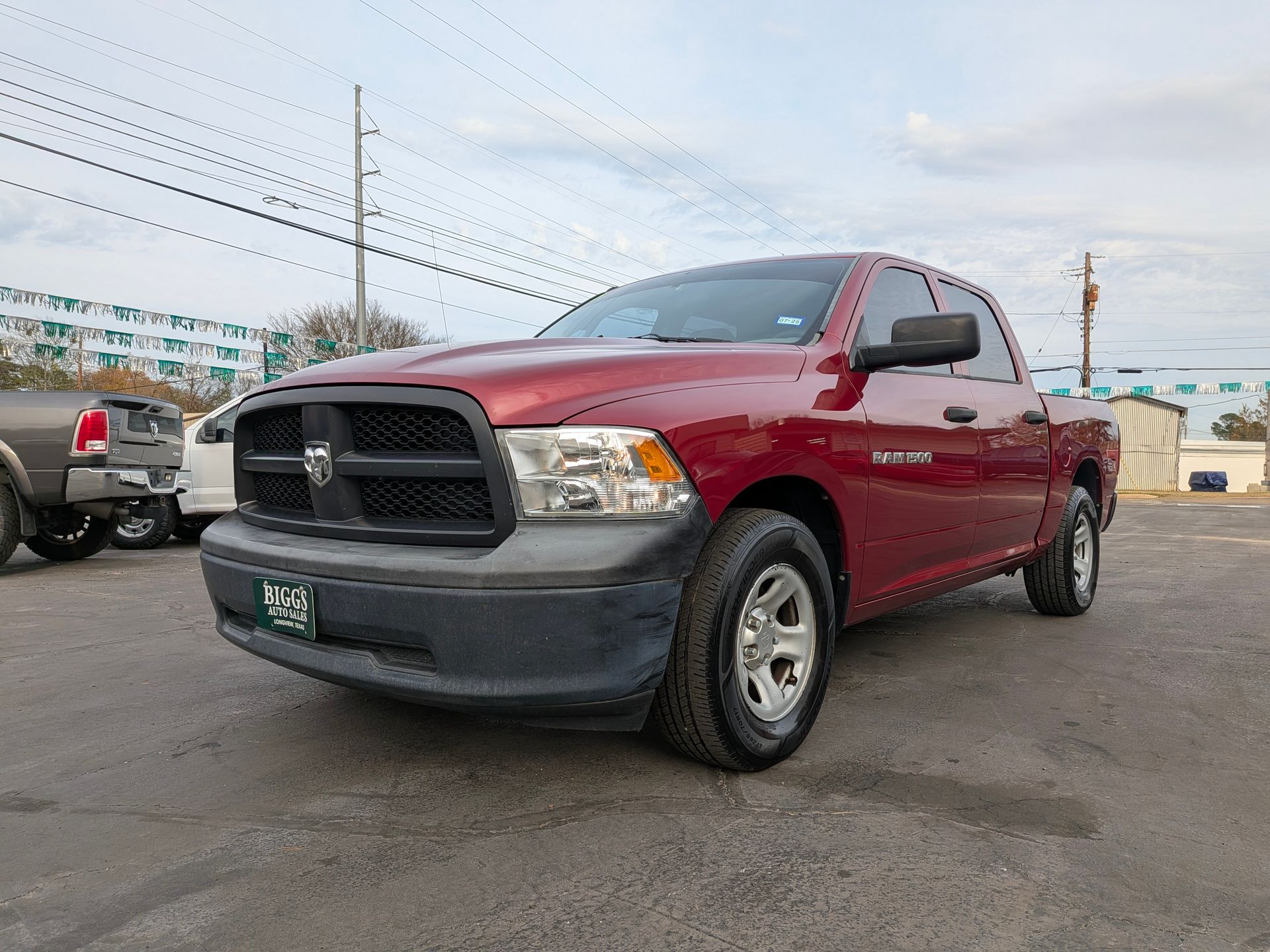 Red Dodge Ram pickup truck parked on asphalt lot.