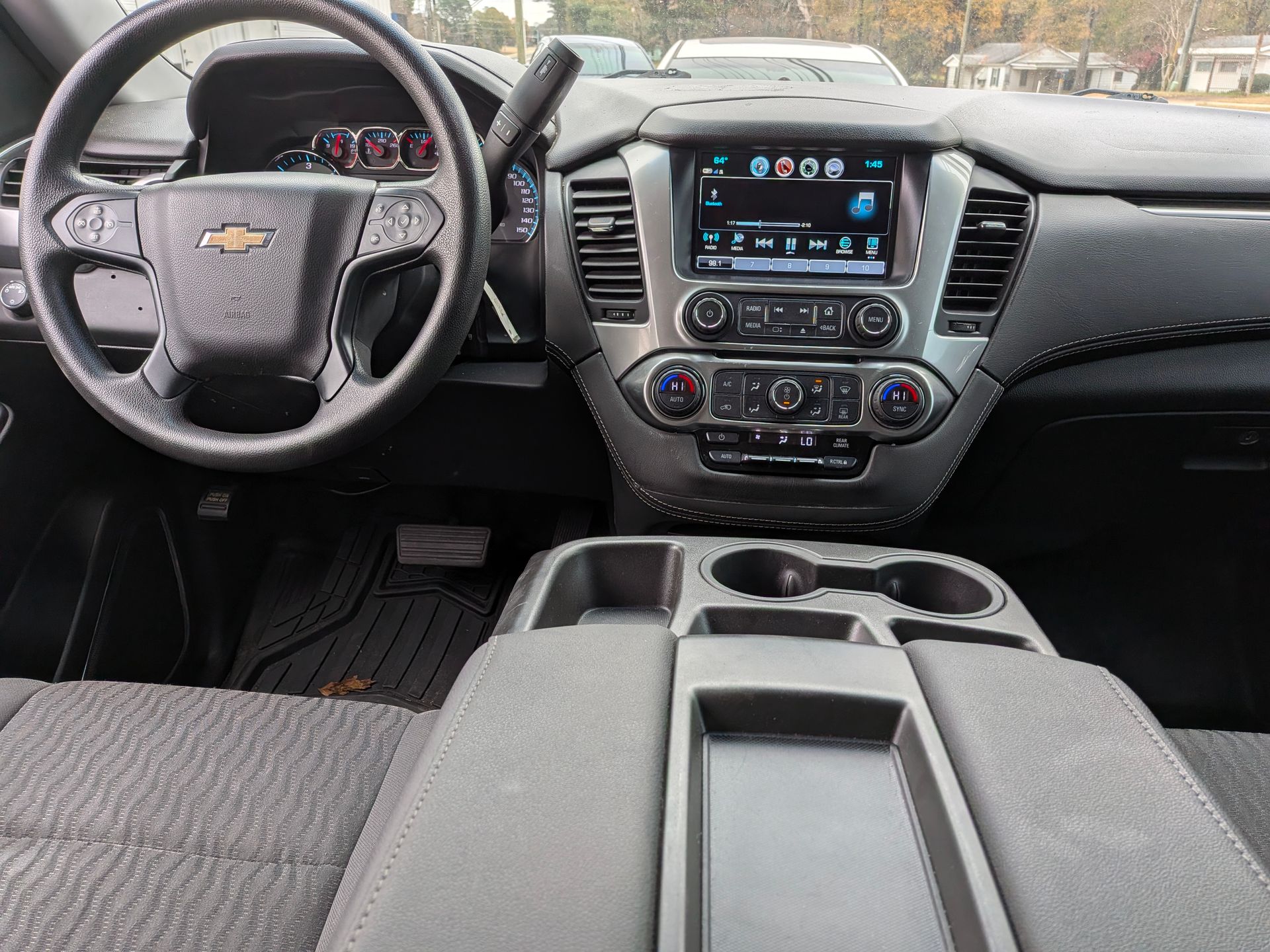Dashboard view of a gray Chevrolet SUV interior, including steering wheel, console, and infotainment screen.