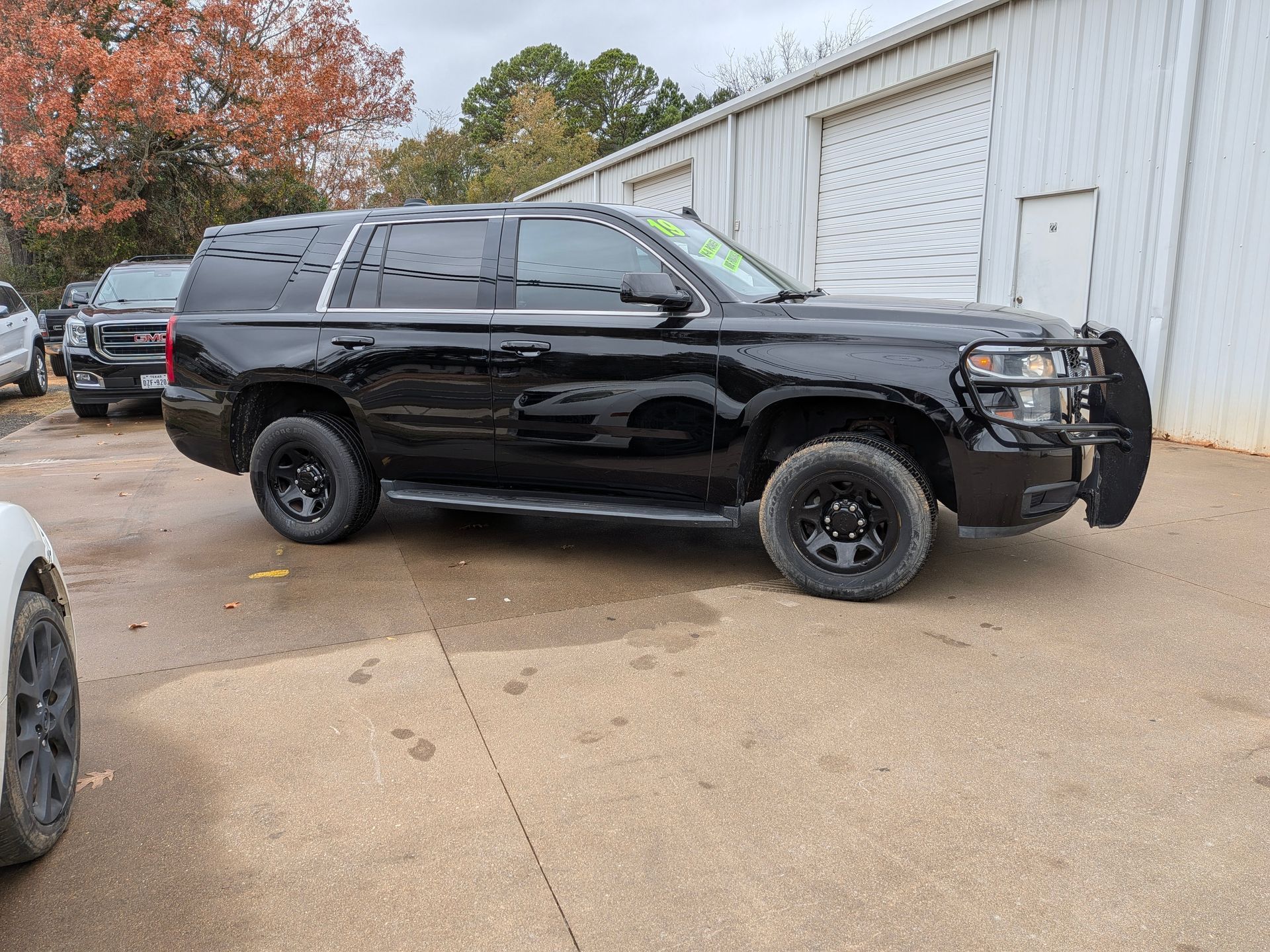 Black SUV with push bar parked outside a building, surrounded by other vehicles.