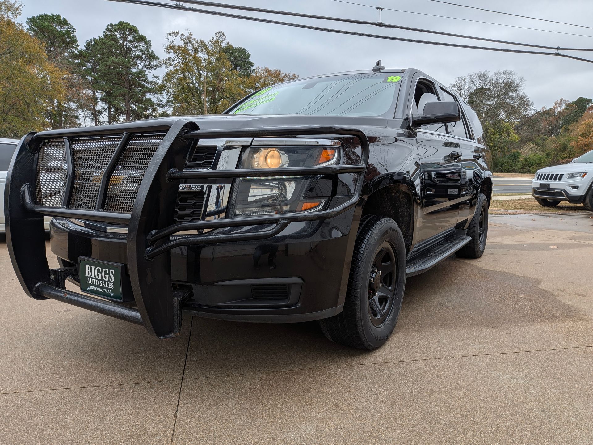 Black SUV with front push bar, parked on a street.
