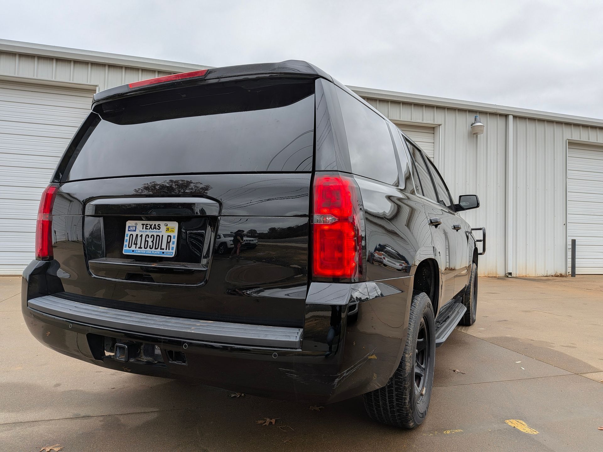 Black SUV parked outside a building with its rear facing the camera.
