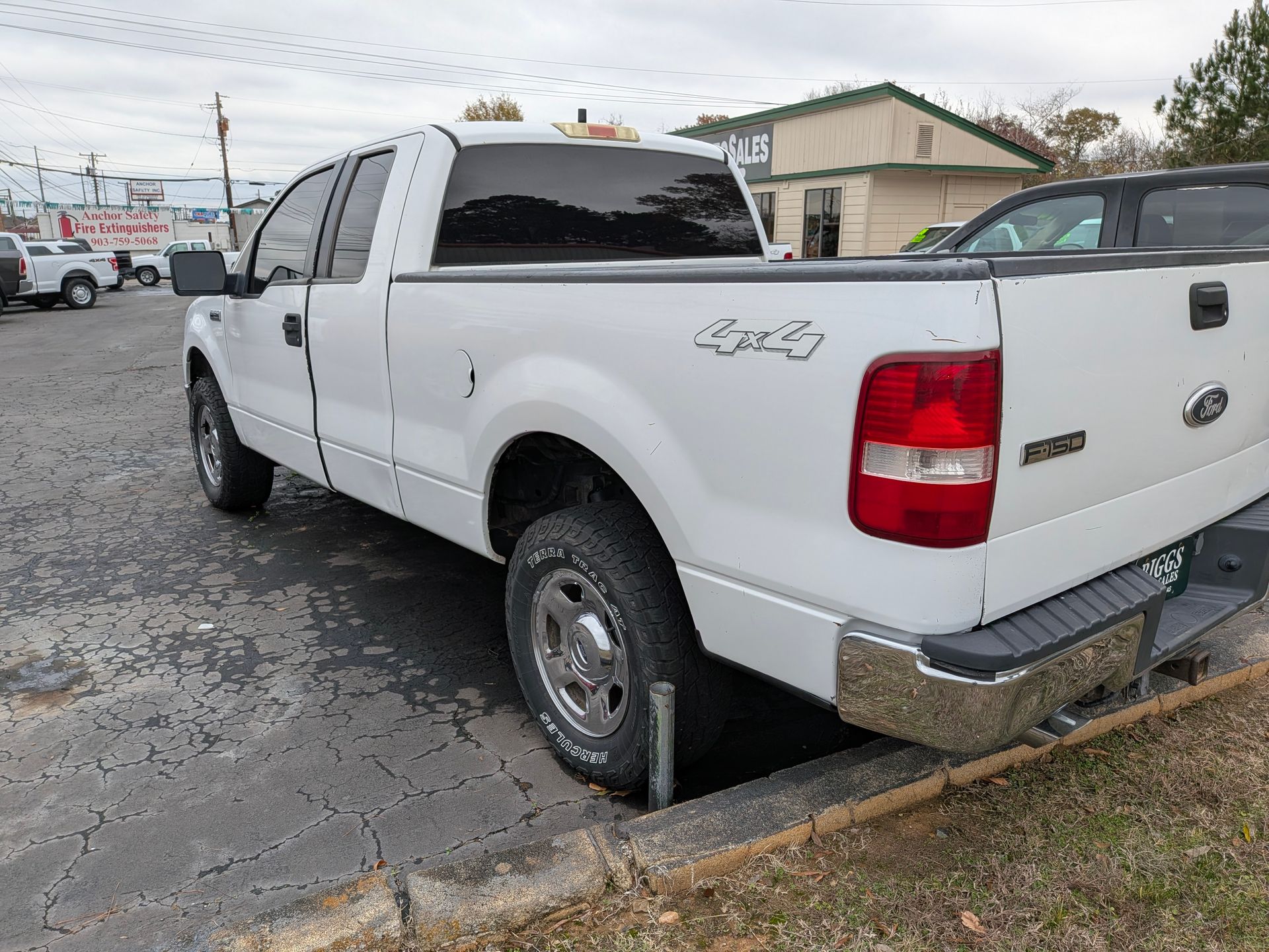 White Ford F-150 truck parked in a lot. The truck has 4x4 on the side.