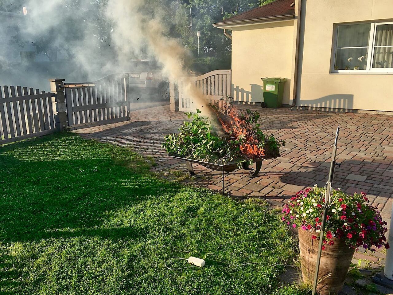 Smoke is coming out of a fire pit in a backyard