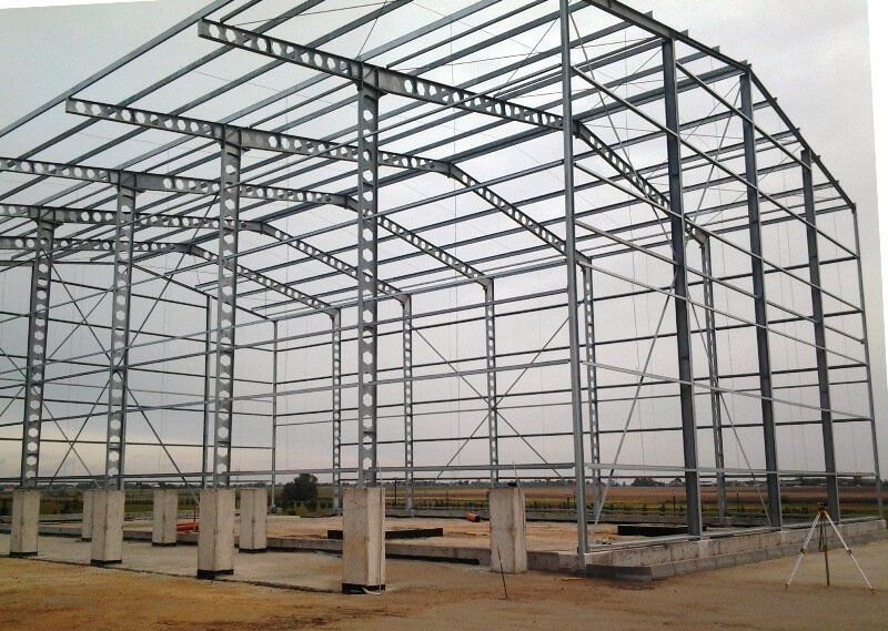 A large metal structure is being built in a field