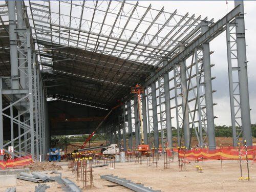 A large metal structure is being built in a field