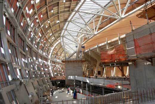 A large building under construction with a lot of windows and a roof.