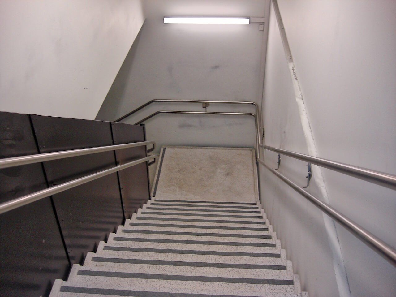 A set of stairs with a metal railing going up