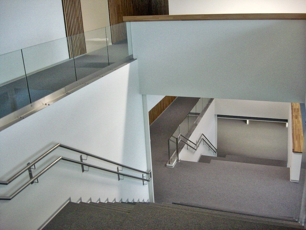A staircase in a building with a glass railing