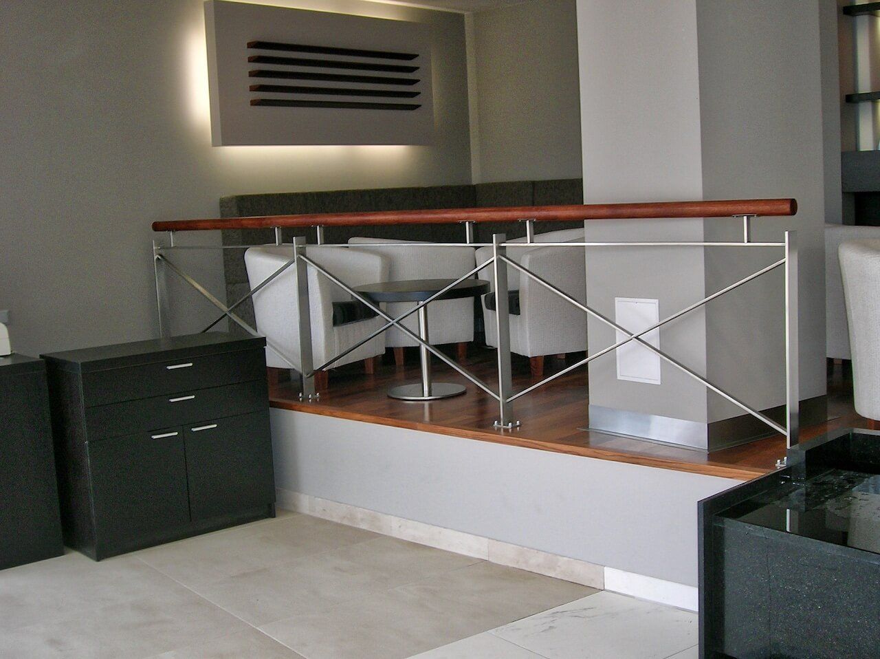 A living room with a staircase leading to a balcony