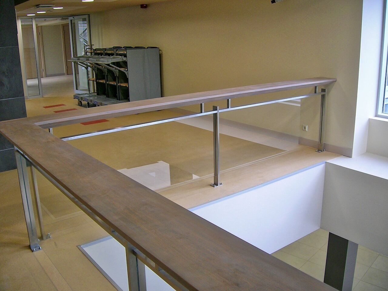 A staircase with a wooden railing and a stainless steel railing