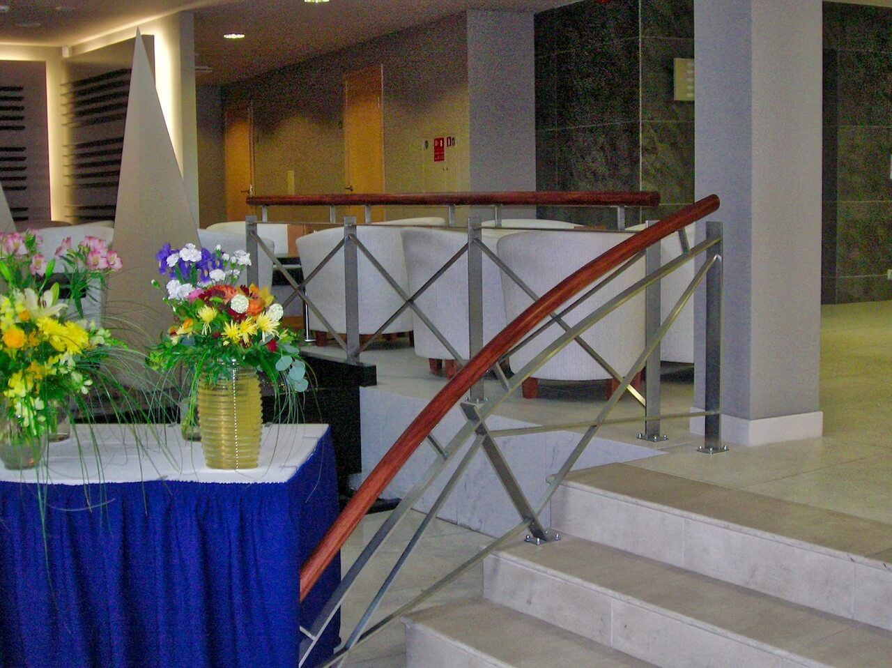 A room with stairs and a table with flowers on it
