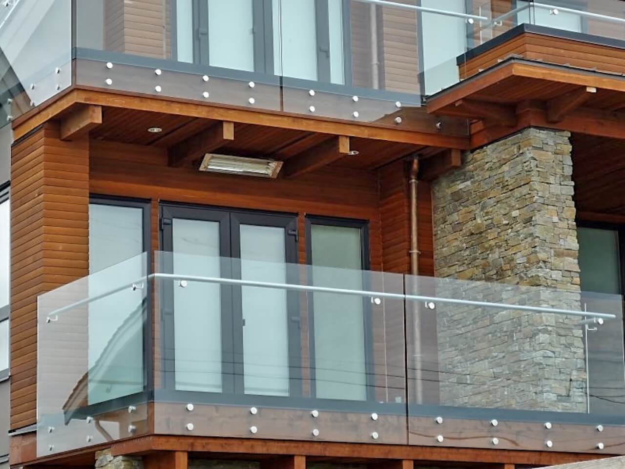 A balcony with a glass railing on the side of a building
