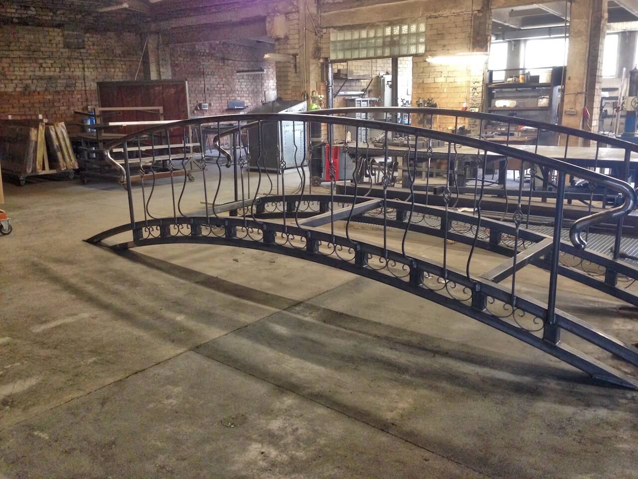 A metal bridge is being built in a warehouse