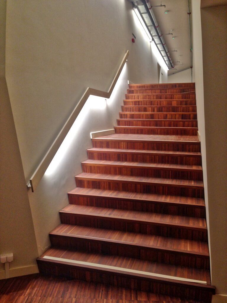 A set of wooden stairs with a white railing